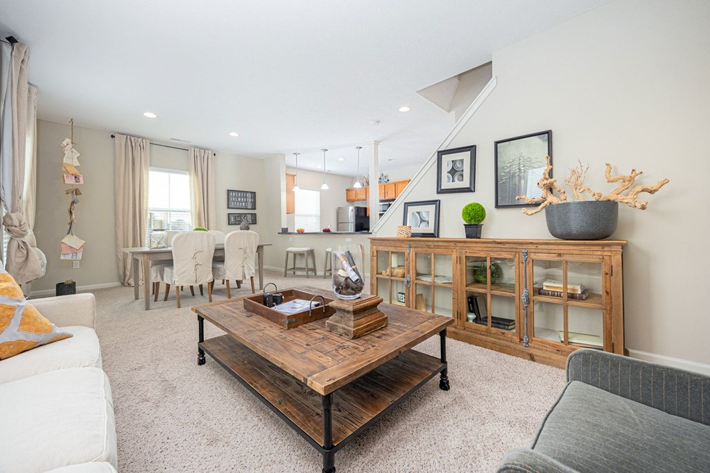 A living room with a white couch, a wooden coffee table, and a grey sofa.