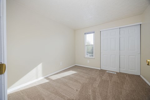 A room with a carpeted floor and a white door.