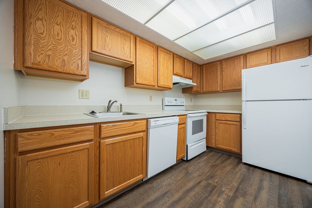 A kitchen with wooden cabinets and a white refrigerator.