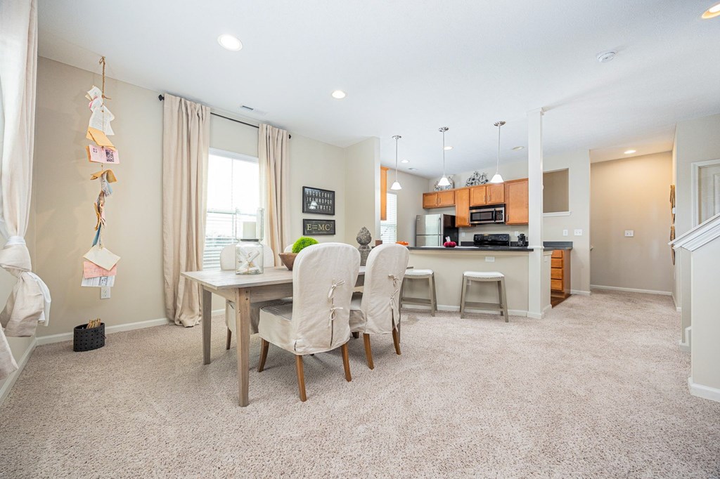A kitchen with a dining table and chairs in the middle of the room.