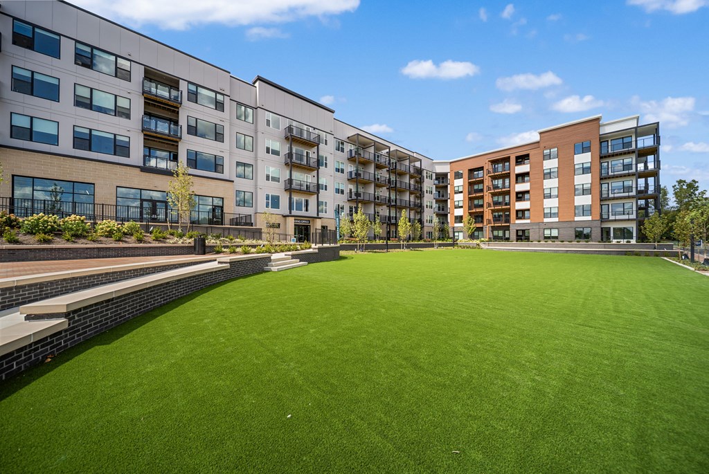 A grassy area in front of apartment buildings.