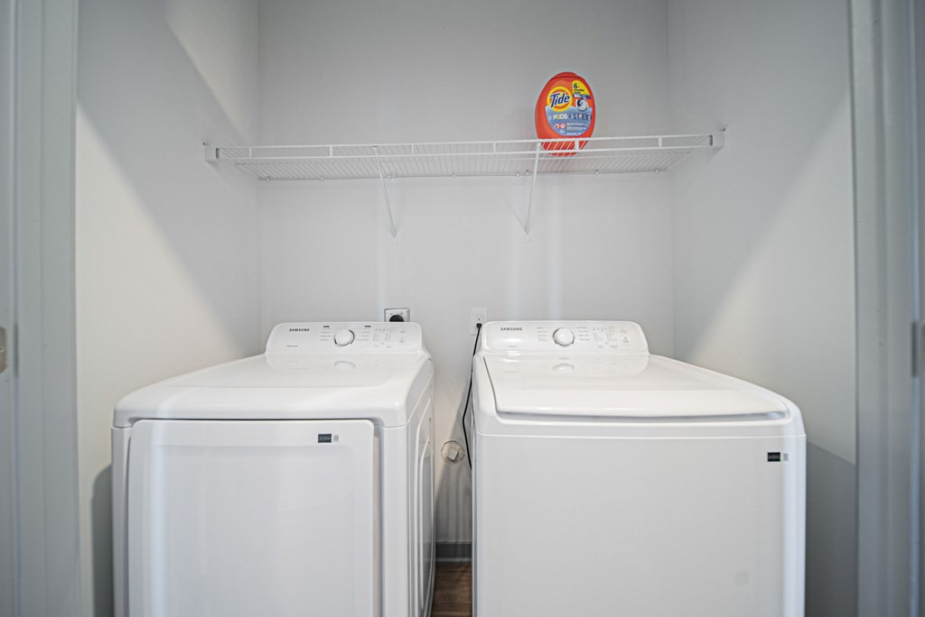 Two white washing machines in a laundry room.
