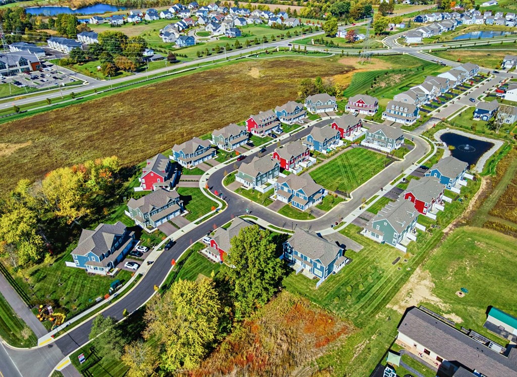 A bird's eye view of a residential neighborhood with houses and a roundabout.