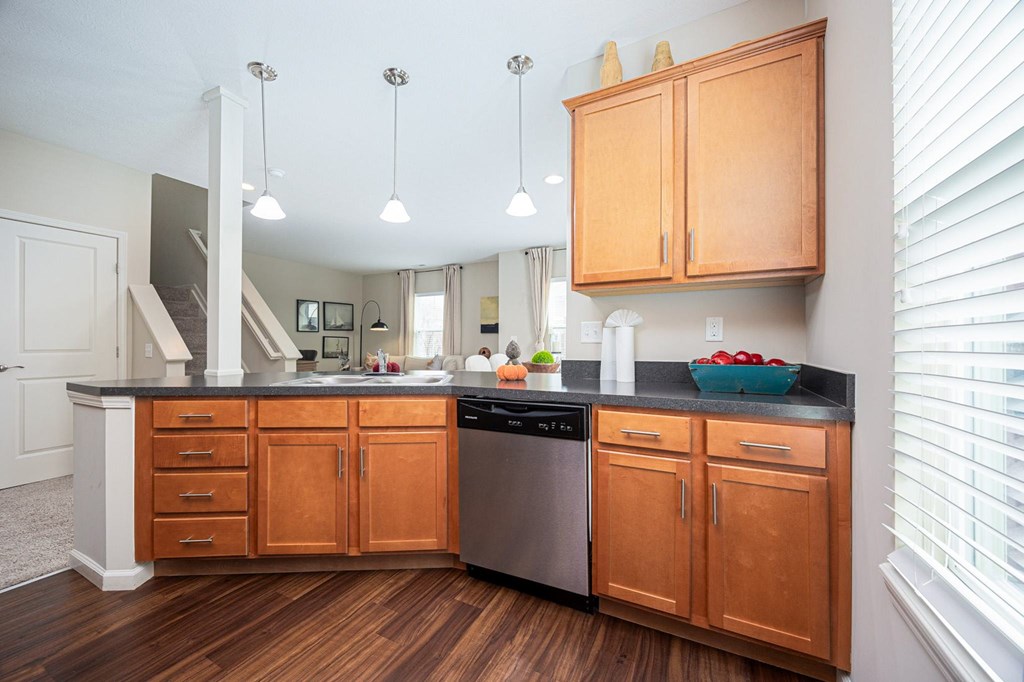 A kitchen with wooden cabinets and a black countertop.