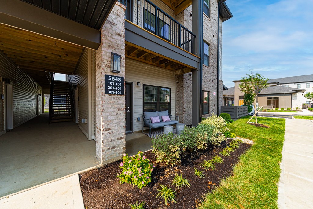 A modern house with a balcony and a garden in front.