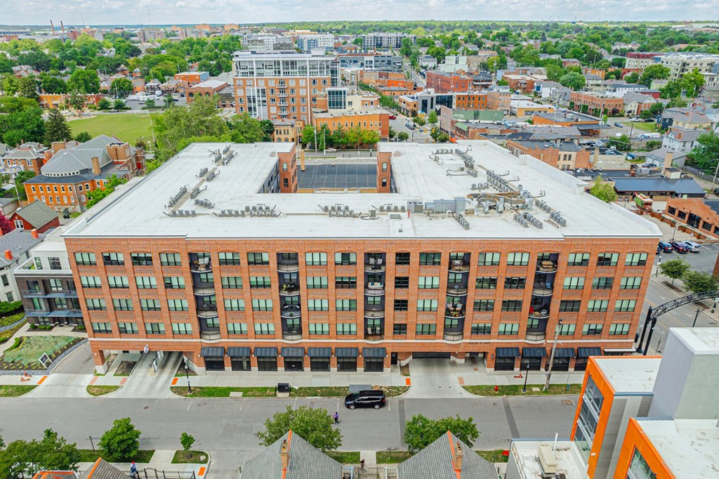 an aerial view of a large brick building with a white roof