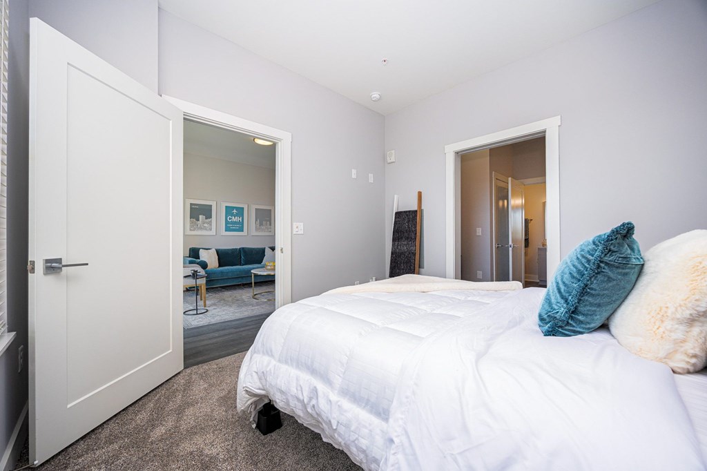 a bedroom with a white bed and a closet