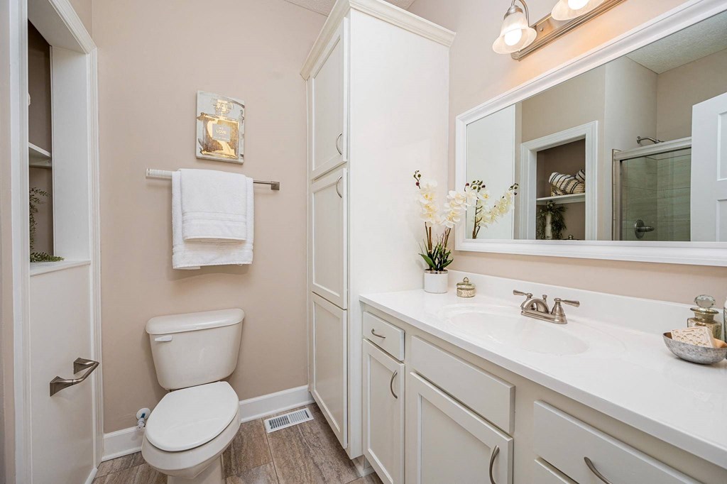 a white bathroom with a toilet and a sink