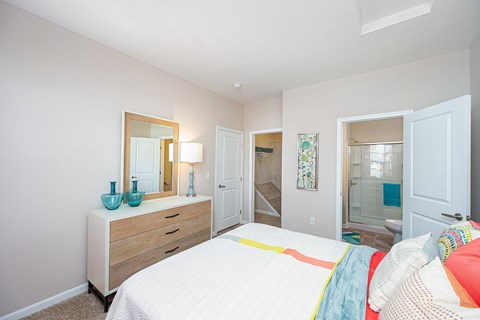 a bedroom with a bed and a mirror and a bathroom