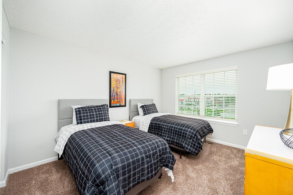 two beds in a room with two windows