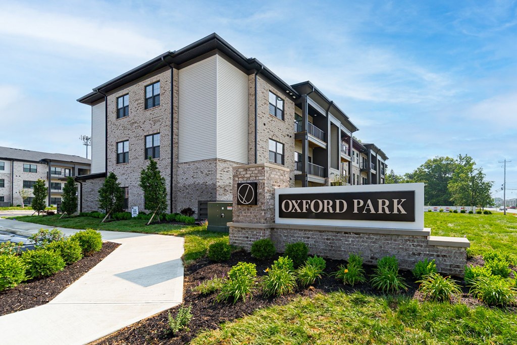 A sign that says Oxford Park in front of some buildings.