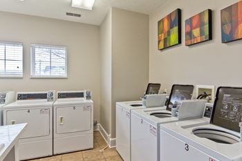 washers and dryers in the laundry room of an apartment building