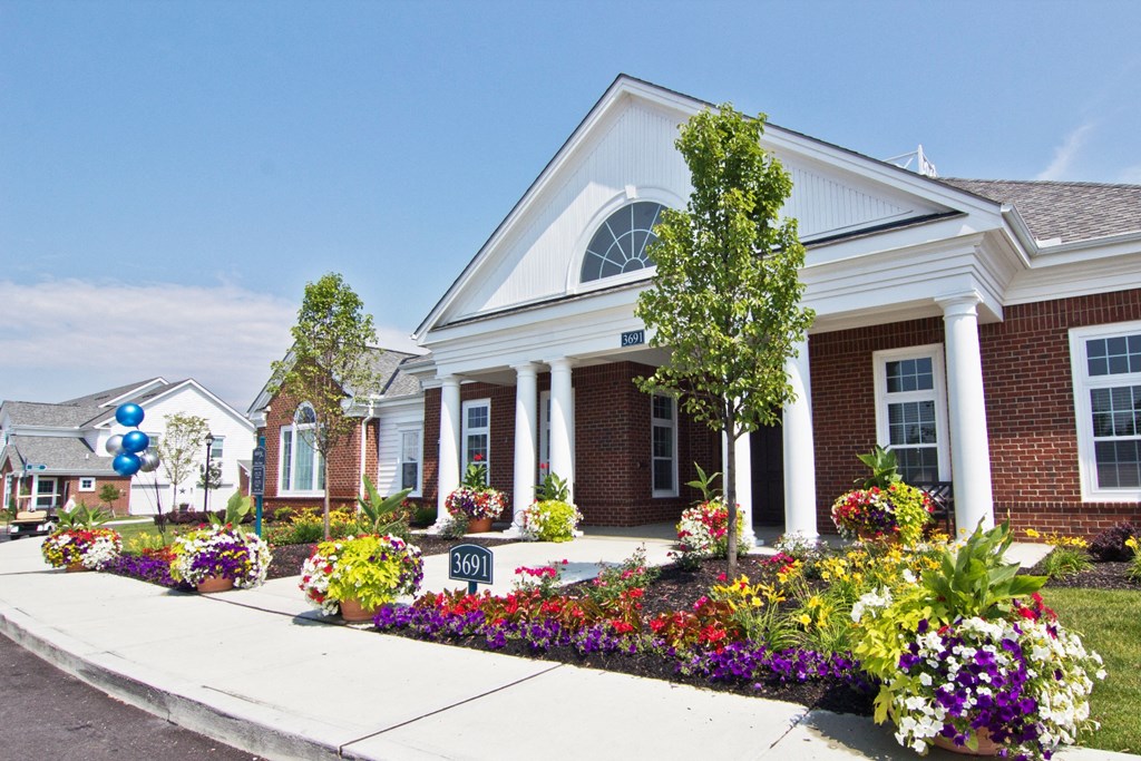 a flower garden in front of a brick building