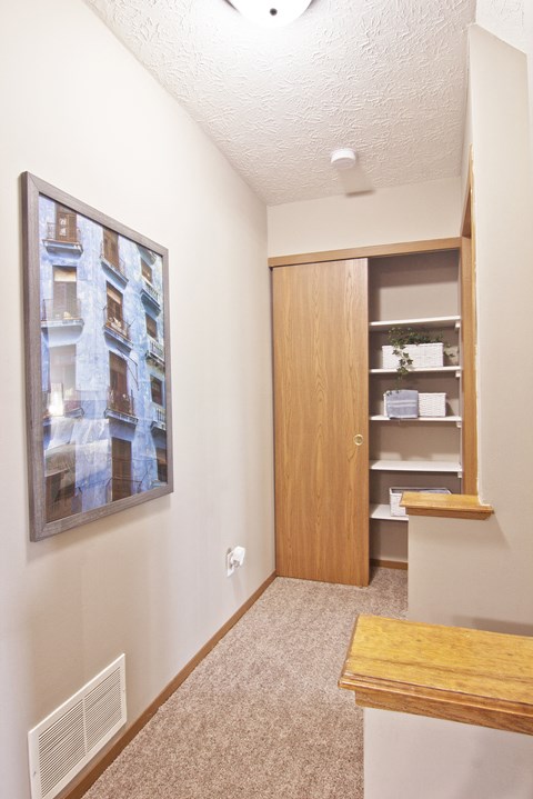 a hallway with a door to a closet and a mirror on the wall