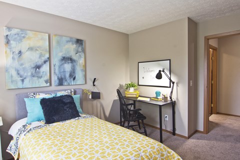 a bedroom with a bed and a desk with a chair