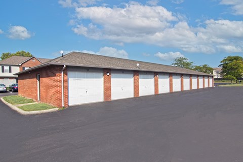 a garage with white doors and red brick walls