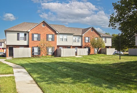 a row of houses on the side of a sidewalk