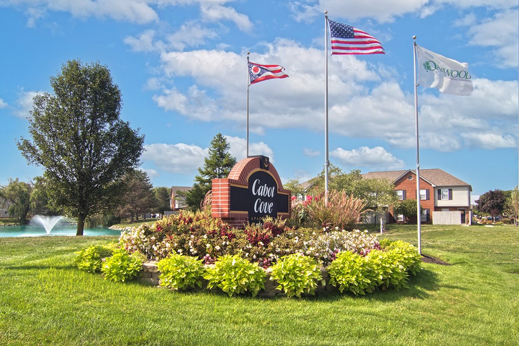 the civic center sign with flags and flowers in the grass