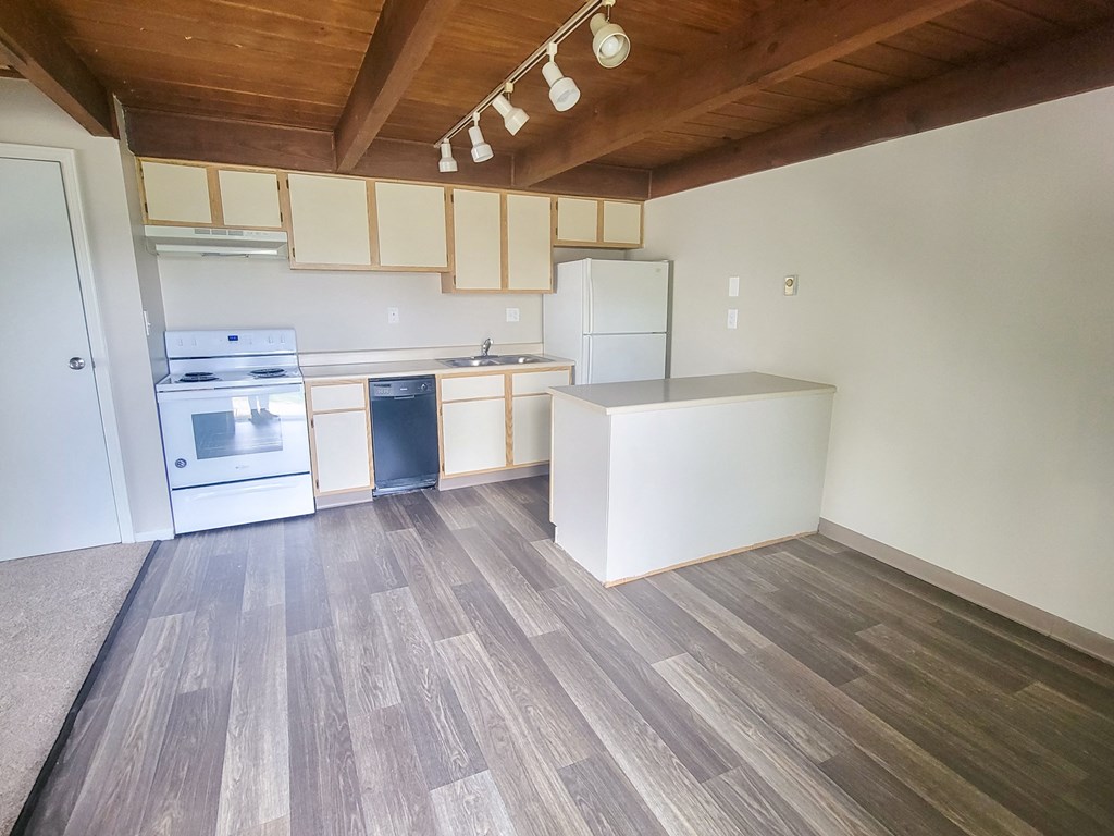a kitchen with white cabinets and a wooden ceiling