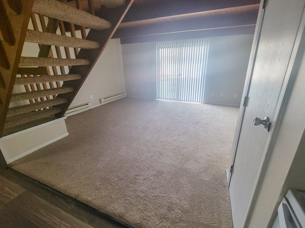 a view from the bottom of the stairs looking into the living room
