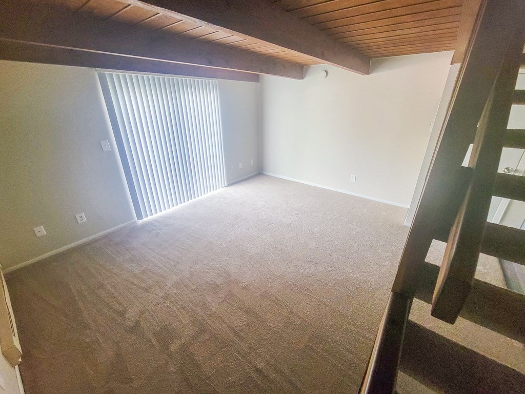 an empty attic with a ladder leading up to a loft