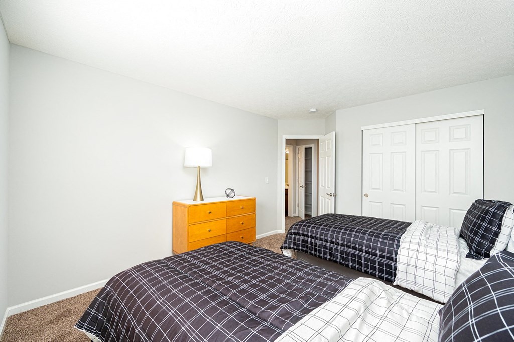 a bedroom with two beds and a closet