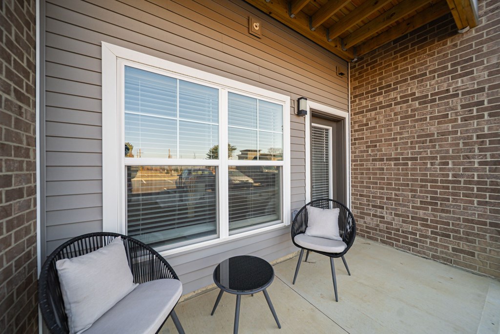 A patio with a chair and a table.