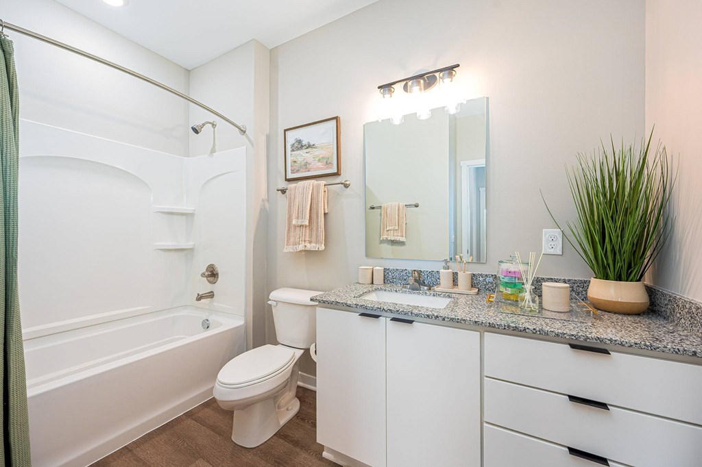 A white bathroom with a toilet, sink, and bathtub.