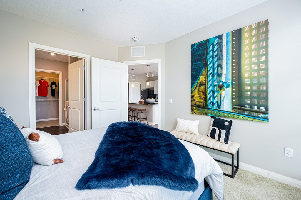 a bedroom with a large bed and a painting on the wall