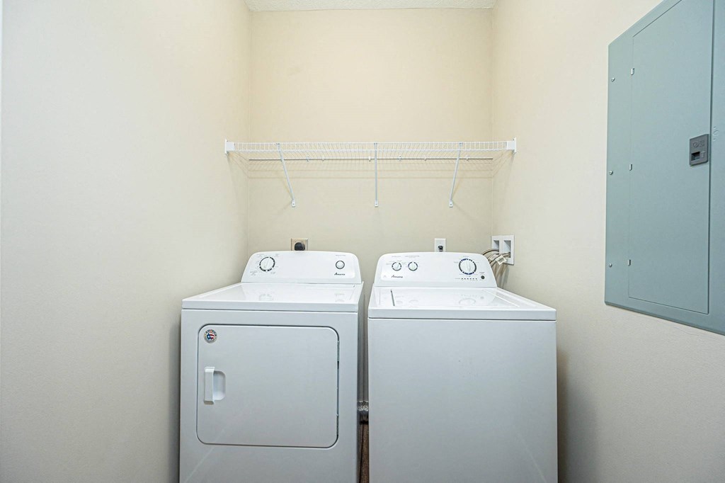 a washer and dryer in a room with a white wall and a closet