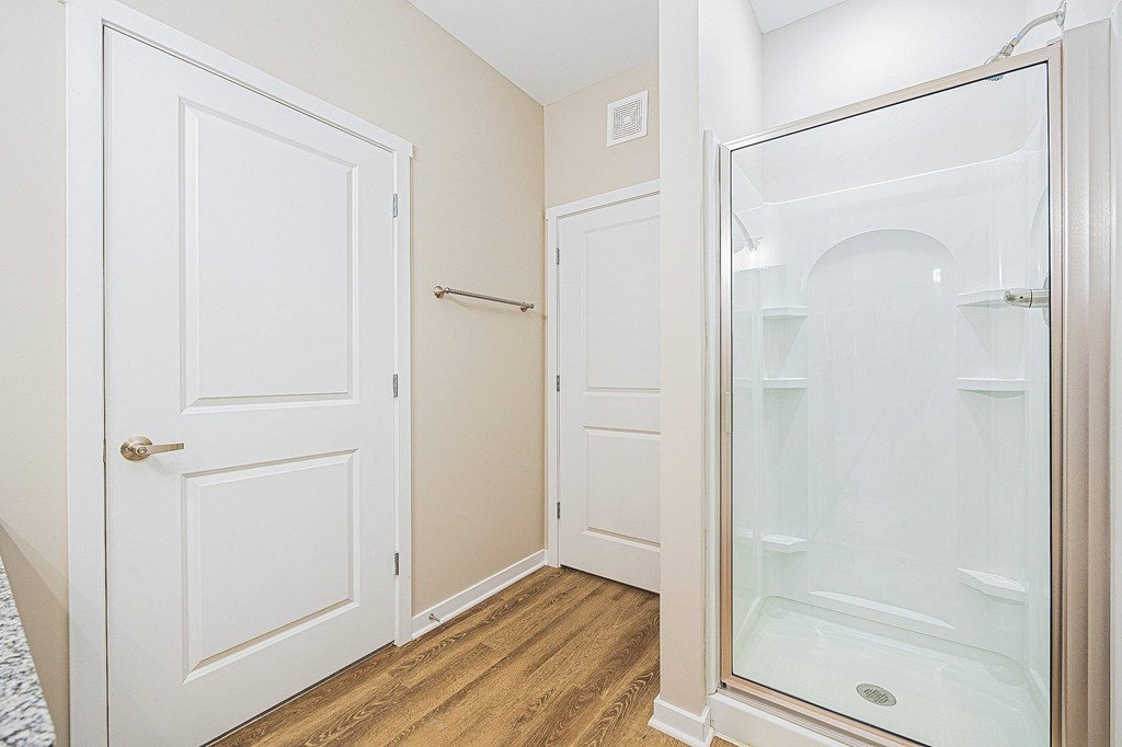 A white door is on the left and a glass shower door is on the right.