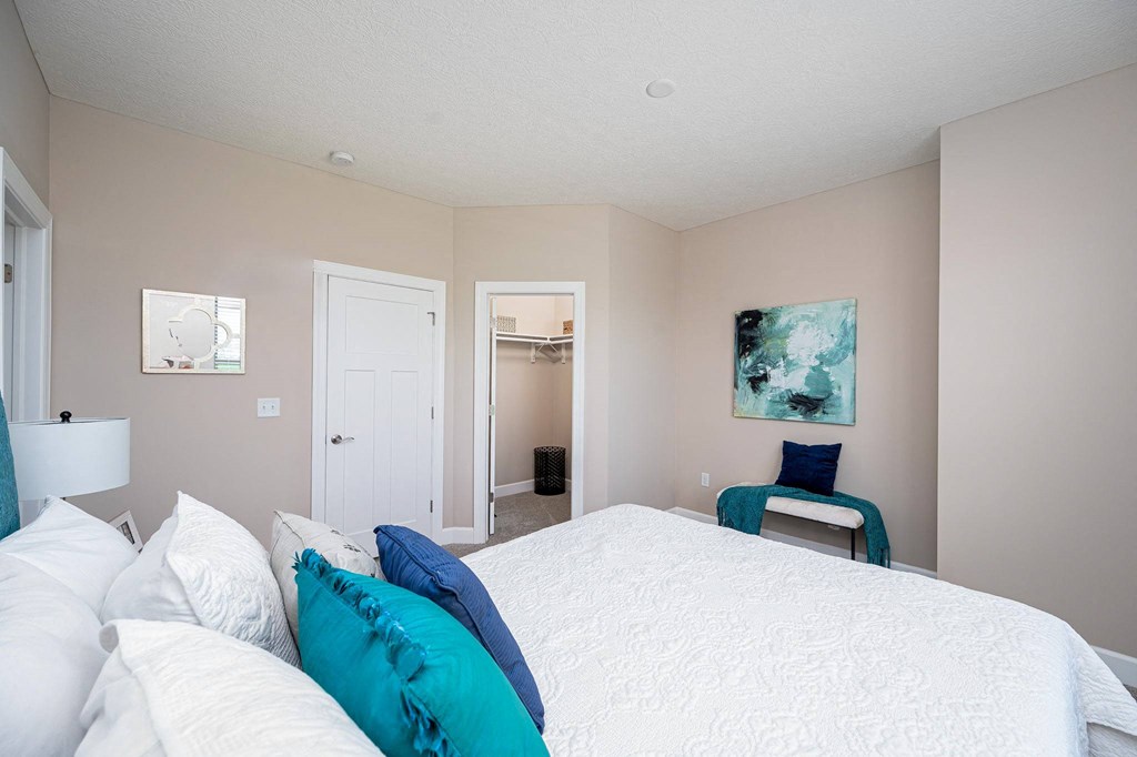 a bedroom with a large bed and a door to a bathroom