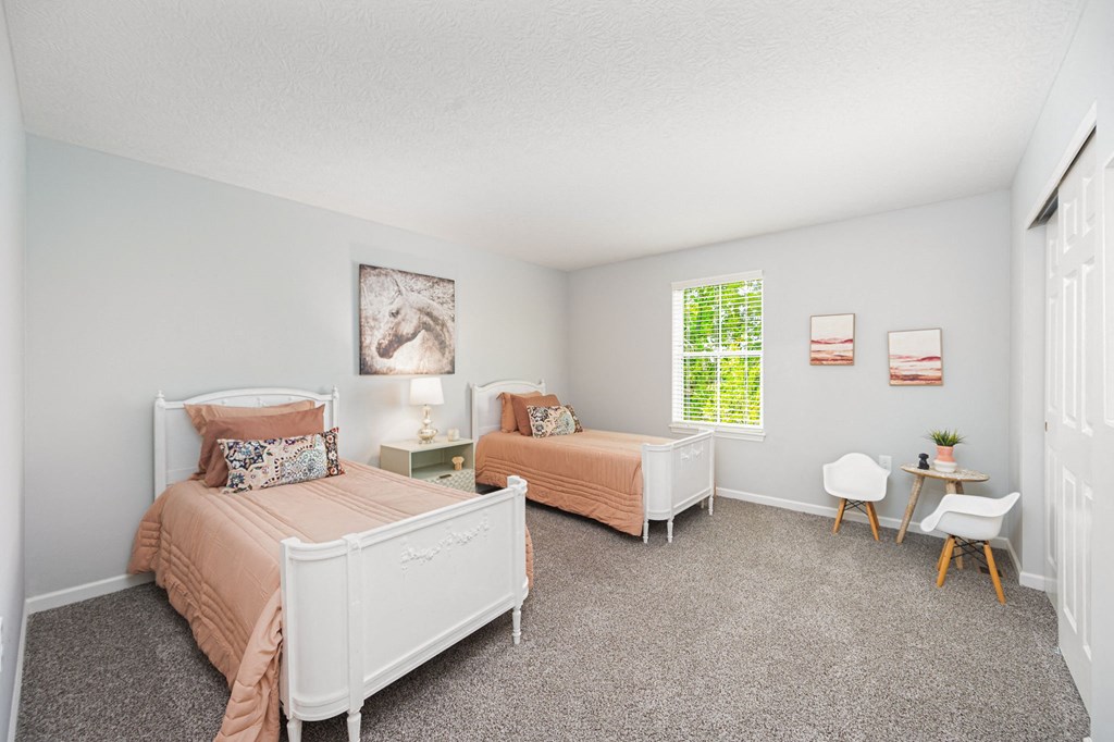 a bedroom with two beds and a window