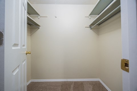 A white door with a gold handle is in a room with a brown carpet.