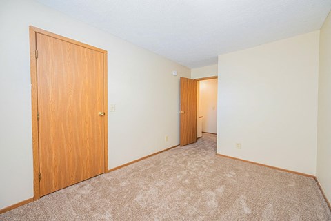 a bedroom with a closet and a door to a hallway