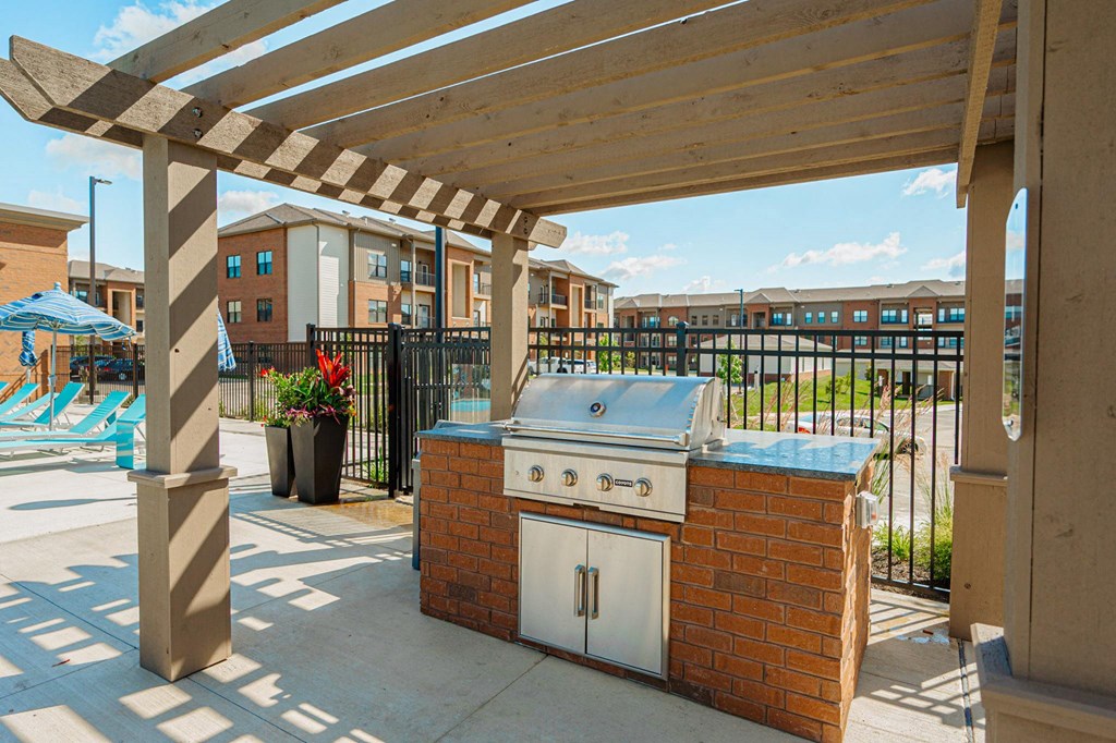 a patio with a barbecue grill and a pool
