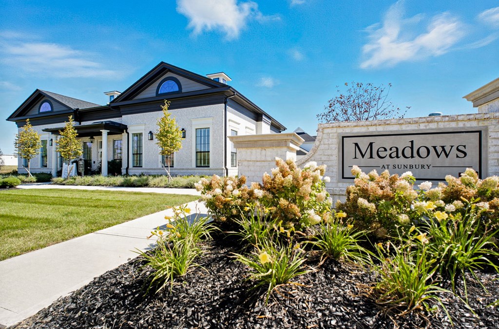 A sign that says Meadows in front of a house.