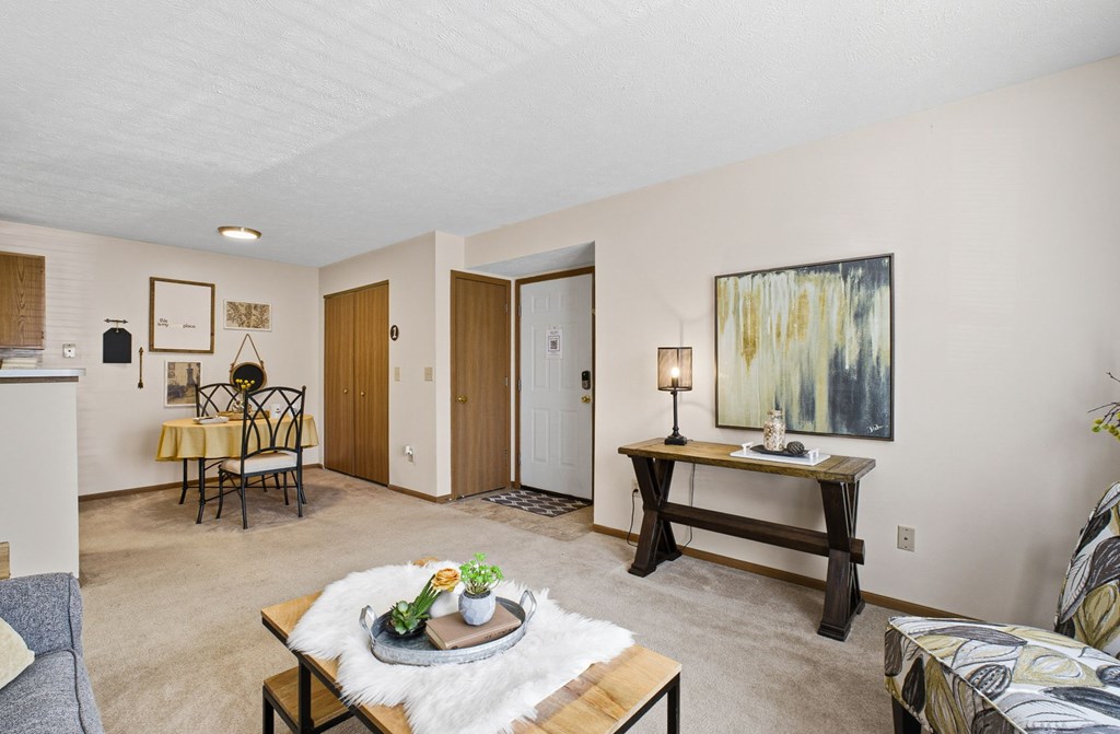 A living room with a couch, coffee table, and a painting on the wall.