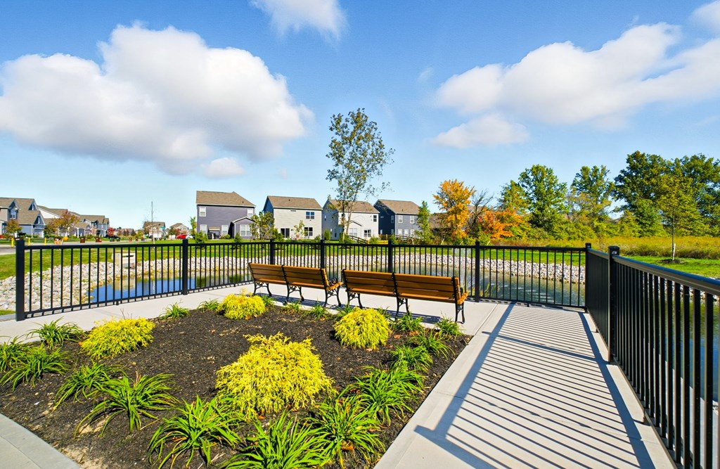 A park with a bench and a fence.