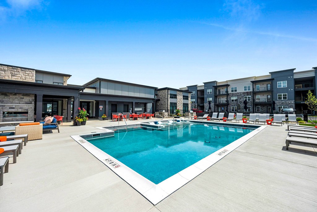 A large outdoor swimming pool with a white edge and a white metal railing.
