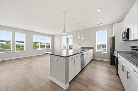 A modern kitchen with white cabinets and a large island.