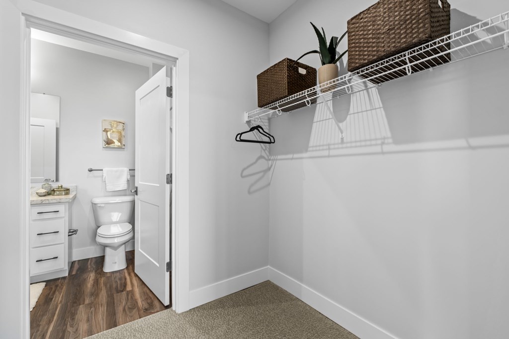 A white bathroom with a toilet, sink, and a white door.