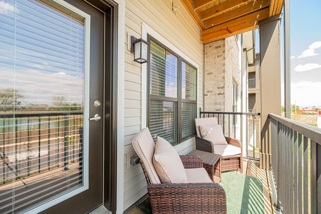 A balcony with a chair and a table.