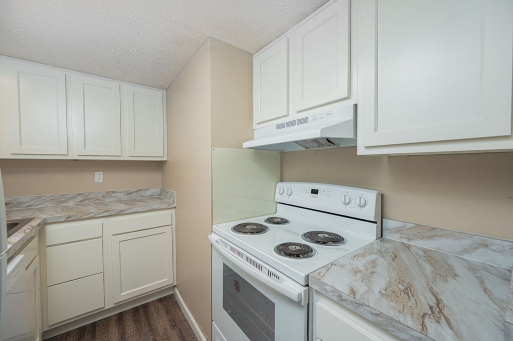 a kitchen with white appliances and marble counter tops