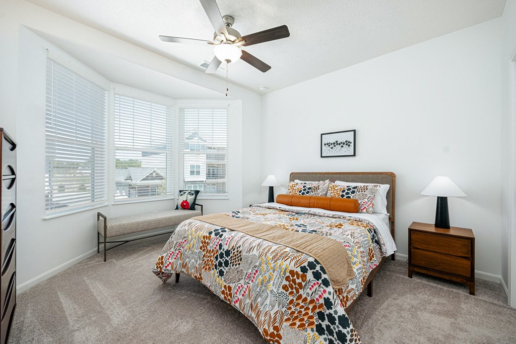 a bedroom with a bed and a ceiling fan