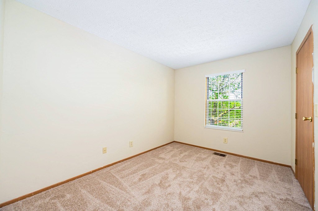a room with carpet and a door and a window