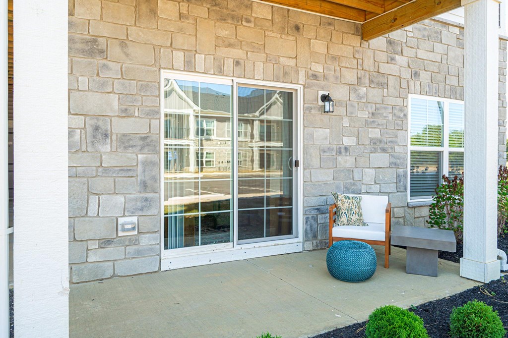 A patio with a white chair and a blue ball.