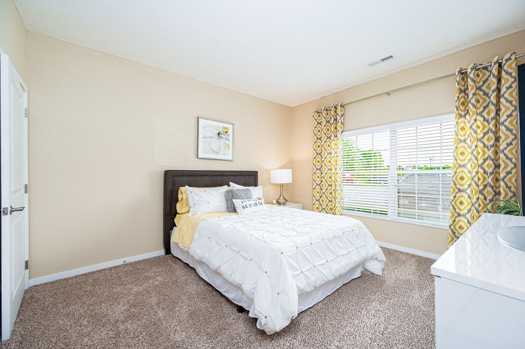 a bedroom with a bed and a large window