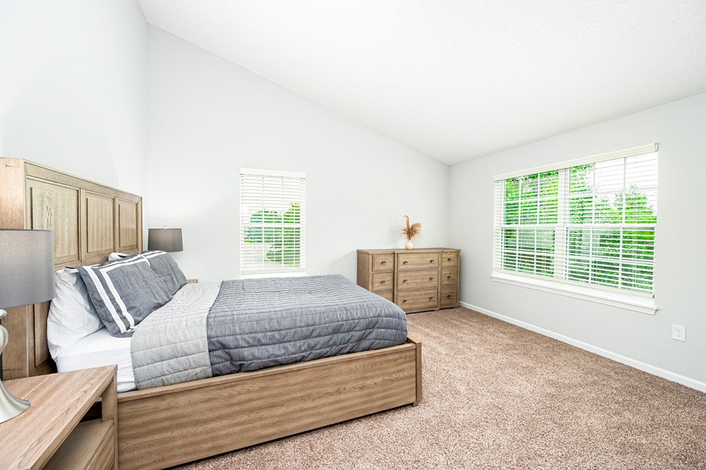 a bedroom with a bed and two windows