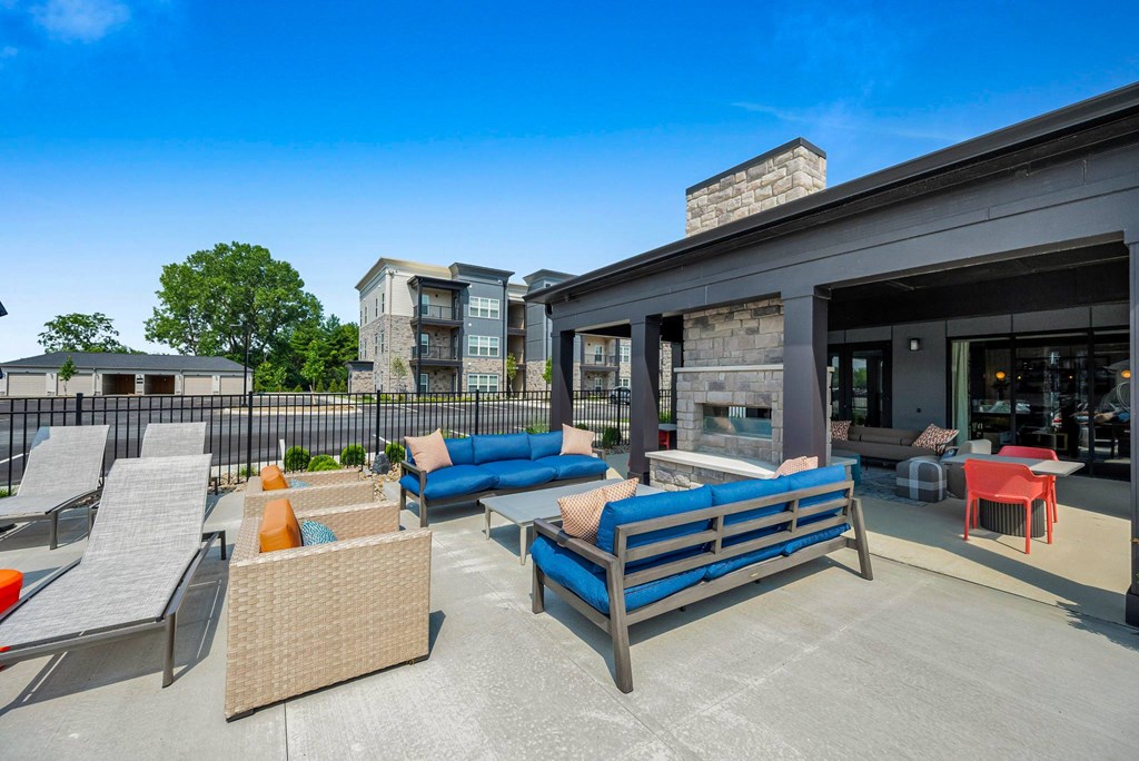 A patio with a blue couch and chairs.